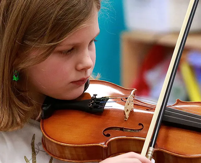 A young student playing the fiddle at a CCÉ Boston Music School class